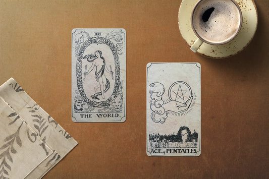 Two tarot cards next to a cup on a brown table