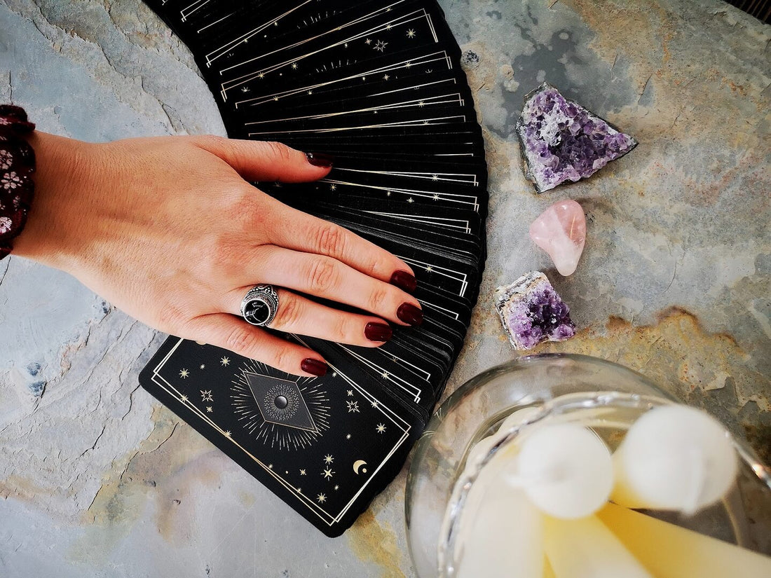 A hand spreading out tarot cards after shuffling a tarot deck