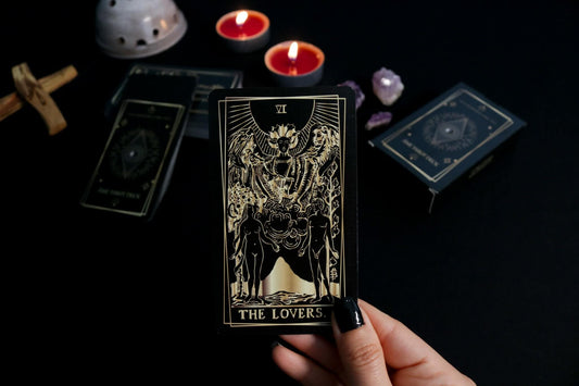 A person holding a card from the Ame tarot deck