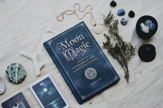 A book of Moon Magic with divination items next to it